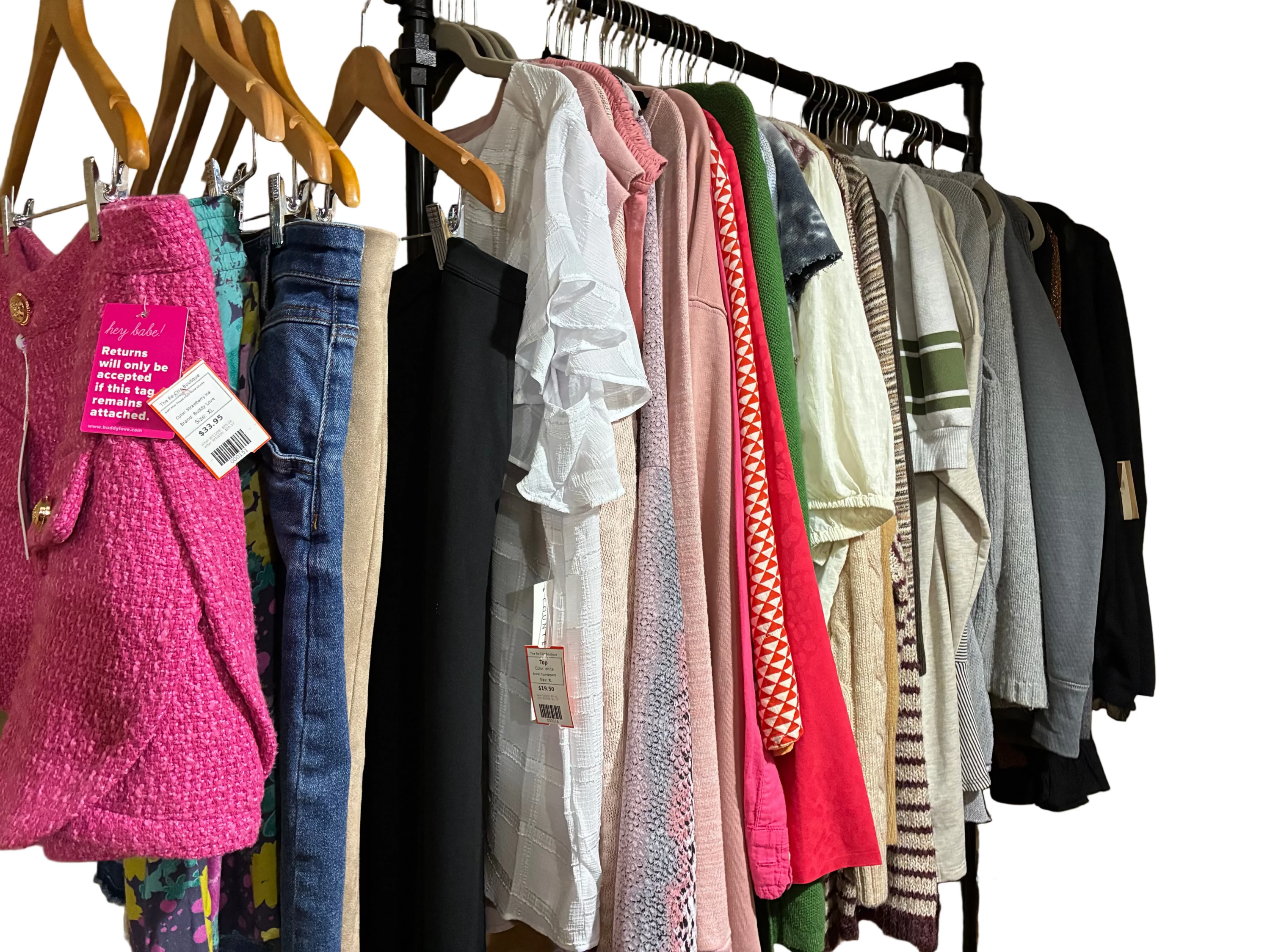 Clothing rack with various garments including a pink sweater and jeans.